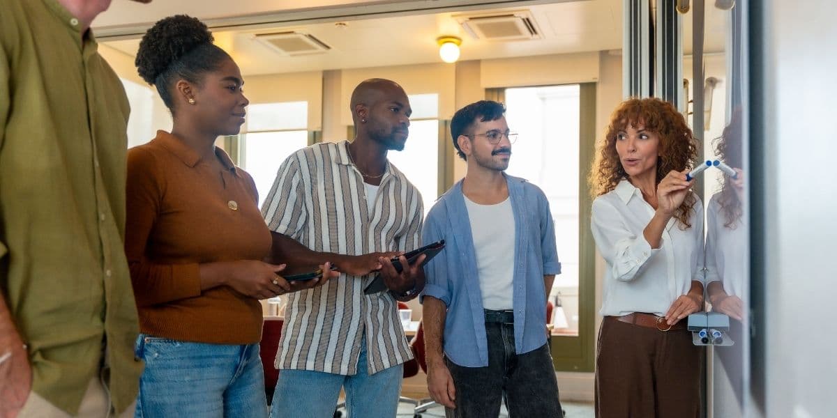 Engineering team collaborating at whiteboard